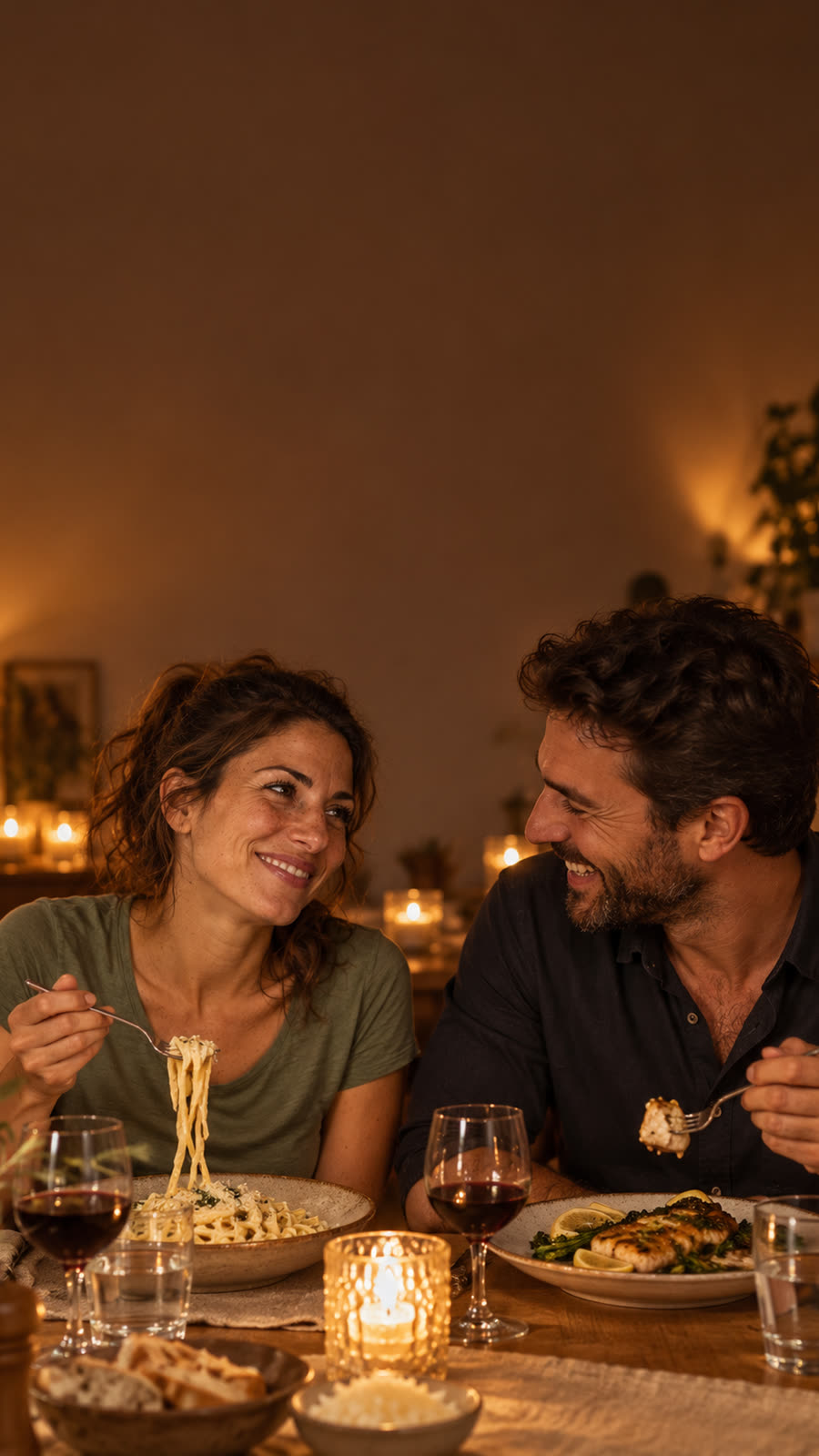 Sara e il compagno ridono a cena, la sera, con i piatti della guida
